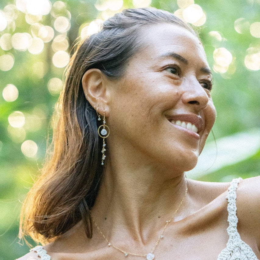 Moonstone and pearl earrings catching low, cool evening light